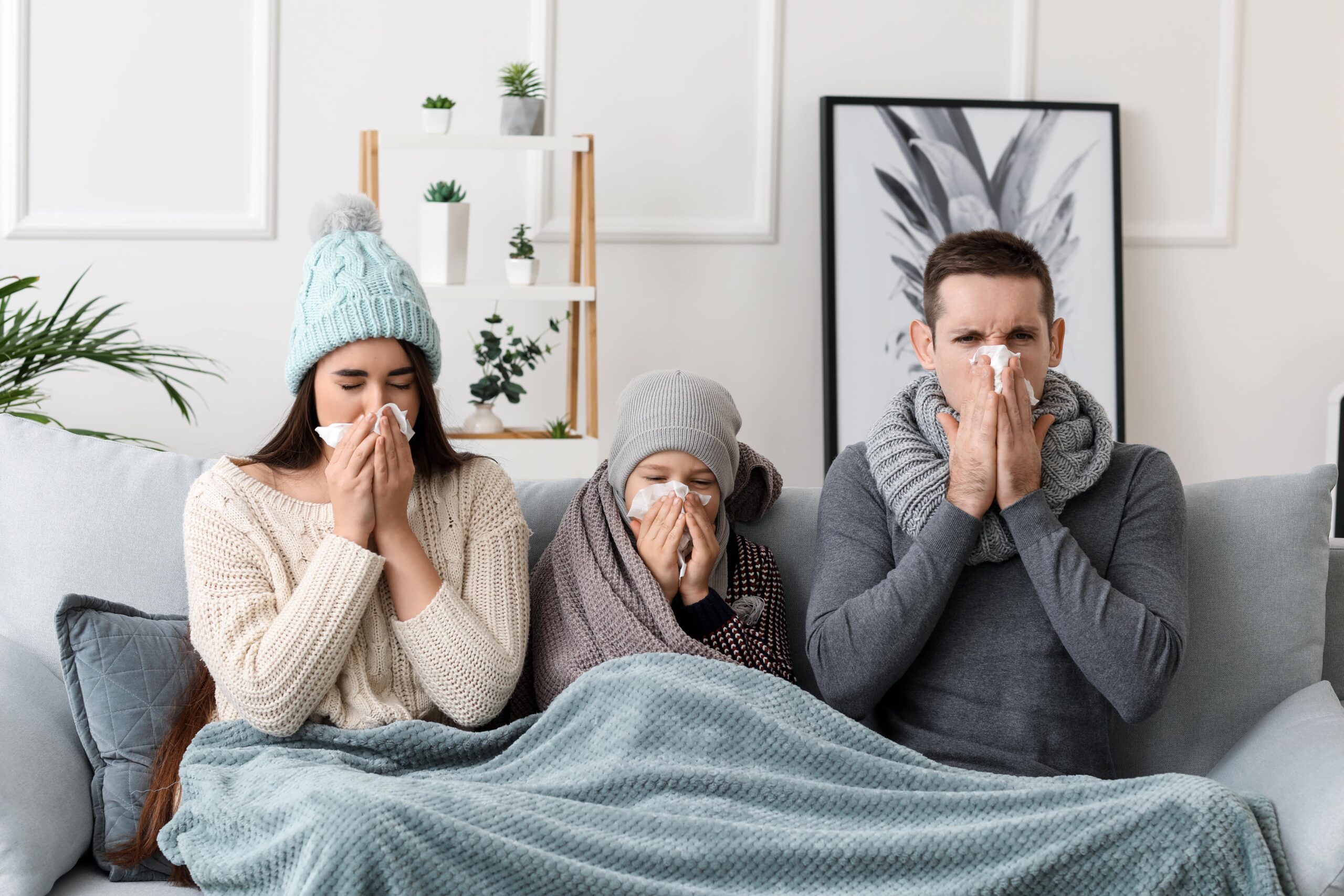 Sick Family Blowing Their Noses While Sitting on Couch