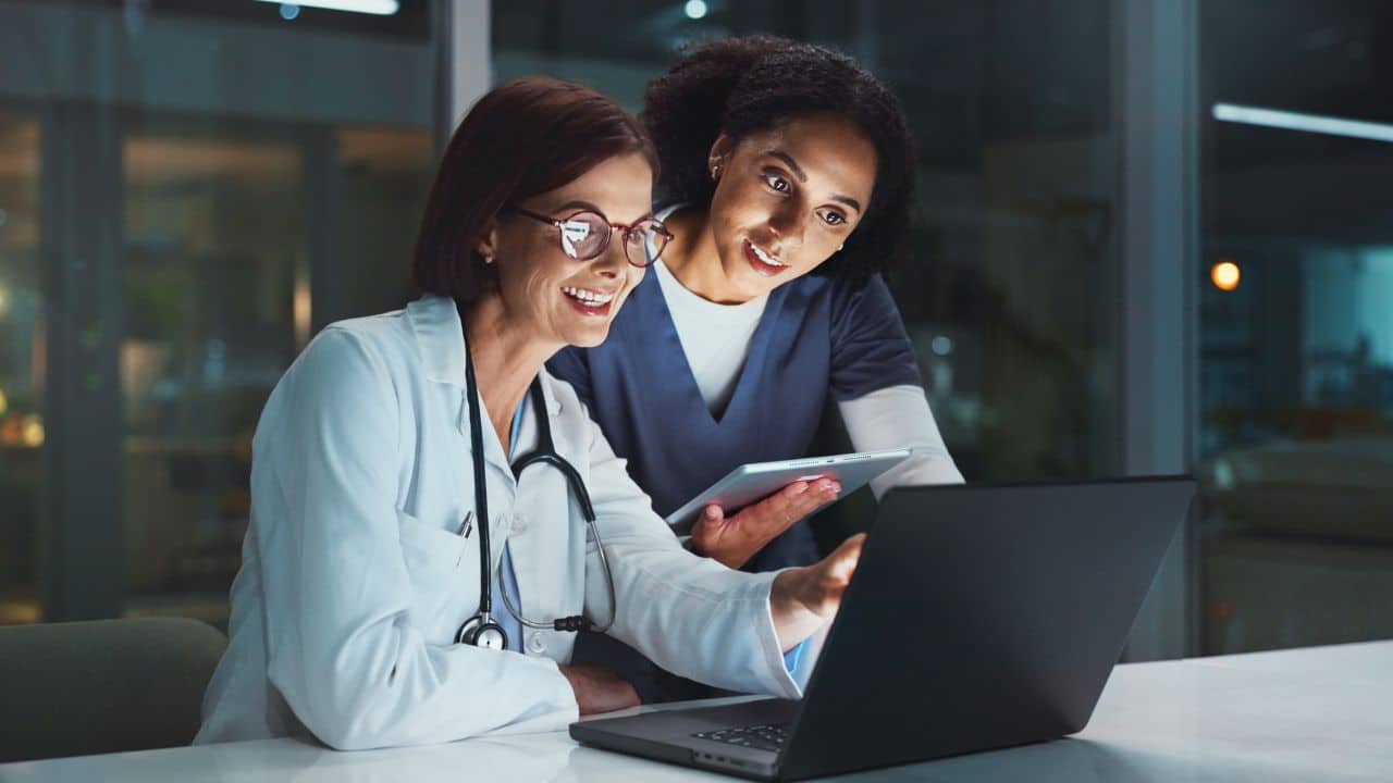 doctor and nurse on laptop for good news or reading online reading doctor and nurse on laptop for good news or reading online reading