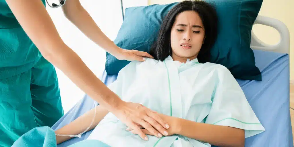 Doctor is holding the patient’s stomach Doctor is holding the patient's stomach